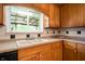 Kitchen featuring wooden cabinets, tiled countertops and backsplash, and a stainless steel sink at 5092 S 50 W, Anderson, IN 46013