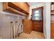 Laundry room with vintage wooden cabinets, tile walls, and an access door to outside at 5092 S 50 W, Anderson, IN 46013