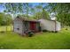 Two sheds sit on a grassy lawn; the one in front is gray with red trim at 5092 S 50 W, Anderson, IN 46013