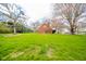 Expansive backyard featuring lush green lawn, mature trees, and privacy hedging at 5939 Olivia Dr, Alexandria, IN 46001