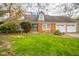Charming brick home featuring a well-maintained lawn, mature trees, and an attached two-car garage at 5939 Olivia Dr, Alexandria, IN 46001