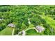 Aerial view of luxurious homes with expansive yards, circular driveways, lush greenery, and a private pool at 5953 Deer Hollow Ct, Pittsboro, IN 46167