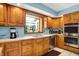 A functional kitchen offers wood cabinetry, stainless steel appliances, and a bright window view at 5953 Deer Hollow Ct, Pittsboro, IN 46167