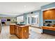 Bright kitchen with island cooktop and breakfast bar seating area adjacent to the living room at 5953 Deer Hollow Ct, Pittsboro, IN 46167