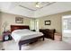 Spacious bedroom with natural light, large bed, dresser, and ensuite bathroom entrance at 5953 Deer Hollow Ct, Pittsboro, IN 46167