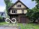 Classic two-story home with Tudor architecture and a detached garage, needing full renovation at 609 E 37Th St, Indianapolis, IN 46205