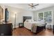 Bedroom featuring a ceiling fan, window, hardwood floors, and simple décor for a cozy, inviting atmosphere at 617 N Dearborn St, Indianapolis, IN 46201