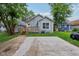 Backyard featuring a wooden deck, driveway, and lush green lawn surrounding the house at 617 N Dearborn St, Indianapolis, IN 46201