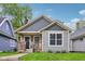 Charming bungalow featuring craftsman architecture, a covered front porch, and a well-maintained lawn at 617 N Dearborn St, Indianapolis, IN 46201