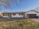 Charming one-story home with white siding, brown shutters, and an attached garage at 619 Belzer Dr, Anderson, IN 46011