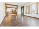 Spacious living room with hardwood floors, green door frame, and open doorway to the dining and kitchen at 619 Belzer Dr, Anderson, IN 46011