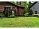 Backyard with a brick house featuring a wooden porch adorned with colorful flowers and green bushes at 6190 Red Day Rd, Martinsville, IN 46151