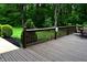 Backyard deck with wooden railing and green bushes overlooking a yard and forest at 6190 Red Day Rd, Martinsville, IN 46151