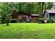 View of brick home with gray siding, wooden porch, and a lush green yard with mature trees at 6190 Red Day Rd, Martinsville, IN 46151
