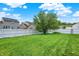 Spacious backyard featuring a mature tree and white vinyl fence, perfect for outdoor activities at 630 Harmony Way, Greenwood, IN 46143