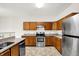 Bright kitchen features stainless steel appliances, tile floors, granite countertops and wooden cabinets at 630 Harmony Way, Greenwood, IN 46143