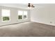 Neutral living room with carpet flooring, lots of light from bright windows, and a ceiling fan at 630 Harmony Way, Greenwood, IN 46143