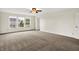 Carpeted living room with bright windows, ceiling fan, neutral paint, and an open floor plan at 630 Harmony Way, Greenwood, IN 46143