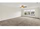 Open floor plan living room features neutral walls, a ceiling fan, carpet, and bright windows at 630 Harmony Way, Greenwood, IN 46143