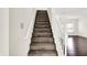 Carpeted staircase with white banister leading up to the second floor living area at 630 Harmony Way, Greenwood, IN 46143