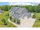 Stunning aerial view of home with expansive driveway, three-car garage, backyard pool and lush landscaping at 644 Ridge Gate Dr, Brownsburg, IN 46112