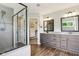 Elegant bathroom featuring a glass shower, dual sinks, and stylish wood-look flooring at 644 Ridge Gate Dr, Brownsburg, IN 46112