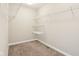Walk-in closet featuring built-in shelves and storage racks plus neutral carpet and paint at 644 Ridge Gate Dr, Brownsburg, IN 46112