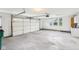 Spacious garage with overhead door, windows, and concrete flooring; perfect for parking and storage at 644 Ridge Gate Dr, Brownsburg, IN 46112