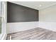 Living room featuring gray accent wall with modern white trim and light wood-look floors at 644 Ridge Gate Dr, Brownsburg, IN 46112