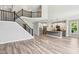Open-concept living room with a staircase, modern kitchen, and luxury vinyl plank flooring at 644 Ridge Gate Dr, Brownsburg, IN 46112