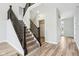 Staircase with carpeted steps, dark wood railing, and wood-look floors in the entry at 644 Ridge Gate Dr, Brownsburg, IN 46112
