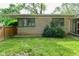 Backyard featuring a well-maintained lawn, mature landscaping, and a combination of grass and gravel at 6550 Sunset Ln, Indianapolis, IN 46260