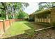 A lush green backyard featuring a well-manicured lawn, mature trees, and a privacy fence at 6550 Sunset Ln, Indianapolis, IN 46260