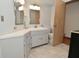 Bright bathroom featuring corner vanity, tiled floor and a separate toilet area at 6550 Sunset Ln, Indianapolis, IN 46260