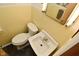 Compact yellow bathroom featuring a toilet, sink, and mirrored medicine cabinet at 6550 Sunset Ln, Indianapolis, IN 46260
