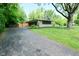 Charming home with a long driveway, mature trees, and well-maintained landscaping at 6550 Sunset Ln, Indianapolis, IN 46260