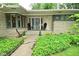 Charming covered front porch with seating and beautiful landscaping at 6550 Sunset Ln, Indianapolis, IN 46260