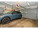 Well-lit garage with a modern car, storage, and functional overhead door at 6550 Sunset Ln, Indianapolis, IN 46260