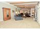 Open living room with exposed beams, comfortable seating, fireplace, and view of the dining room at 6550 Sunset Ln, Indianapolis, IN 46260