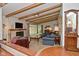 Spacious living room with exposed beams, fireplace, and glass doors to the outside at 6550 Sunset Ln, Indianapolis, IN 46260