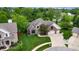 Aerial view of home featuring brick and stone exterior, well-kept lawn, mature trees, and a three-car garage at 8338 Hunters Meadow Way, Indianapolis, IN 46259