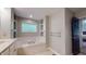 Relaxing bathroom features a soaking tub, glass block window, and convenient built-in shelving at 8338 Hunters Meadow Way, Indianapolis, IN 46259