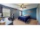 Comfortable bedroom featuring chevron accent wall, ceiling fan, and a dedicated desk area at 8338 Hunters Meadow Way, Indianapolis, IN 46259