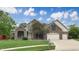 Traditional two-story brick and stone home with an attached three-car garage and a lush lawn at 8338 Hunters Meadow Way, Indianapolis, IN 46259