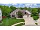 Charming brick and stone two-story home with a well-manicured lawn and three-car garage at 8338 Hunters Meadow Way, Indianapolis, IN 46259