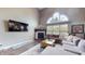 Comfortable living room with a corner fireplace, large windows, and a plush sectional sofa at 8338 Hunters Meadow Way, Indianapolis, IN 46259