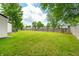 Expansive backyard with green grass and wooden fence, perfect for outdoor activities and relaxation at 8416 Buckingham Dr, Columbus, IN 47201