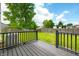 Black wooden deck overlooking the backyard with green grass and a wooden fence at 8416 Buckingham Dr, Columbus, IN 47201