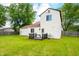 Back exterior view of the home with a wooden deck, lush green grass, and white siding at 8416 Buckingham Dr, Columbus, IN 47201