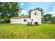 Back exterior view of the home with a wooden deck, green grass, and white siding at 8416 Buckingham Dr, Columbus, IN 47201